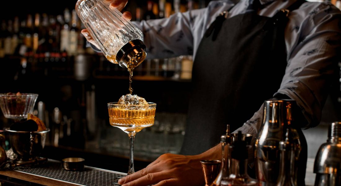 Bartender at local bar pouring a cocktail