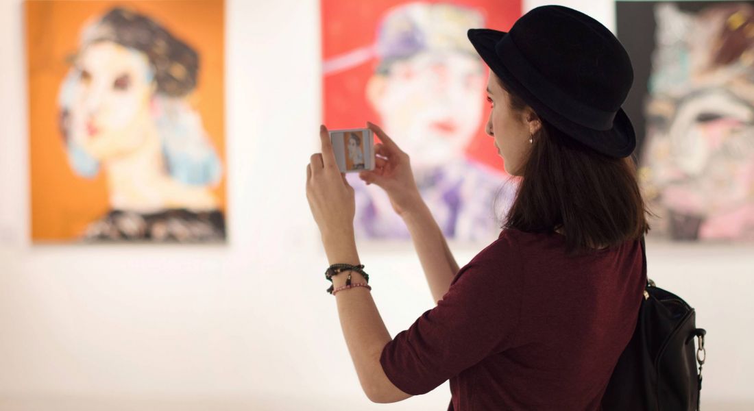 Woman at art gallery looking at painting