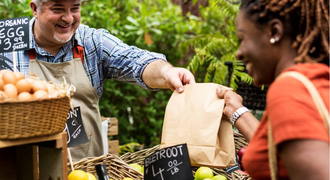 Greengrocer selling organic fresh agricultural product at farmer market